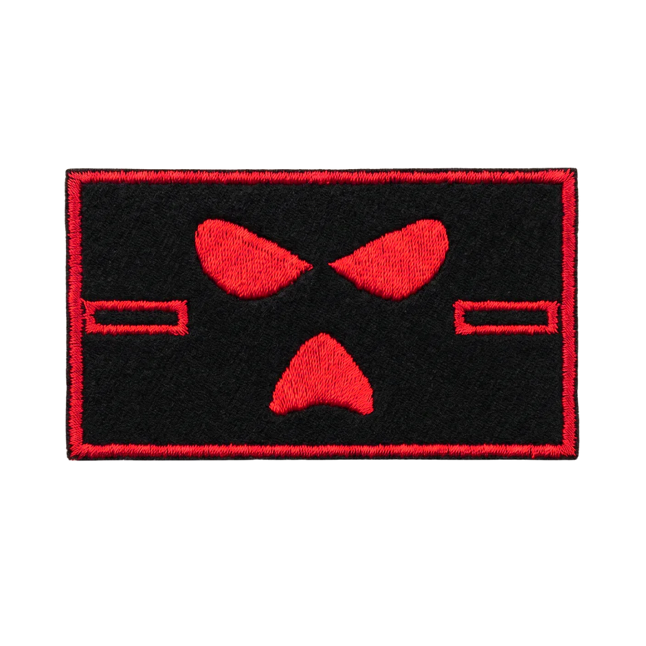 A rectangular black embroidered patch with a red border and a stylized red mask or face design in the center, shown on a plain white background.